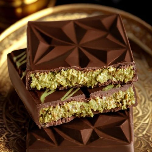 Dubai-Schokoladentafel, in zwei Hälften geöffnet, auf einem goldenen Tablet