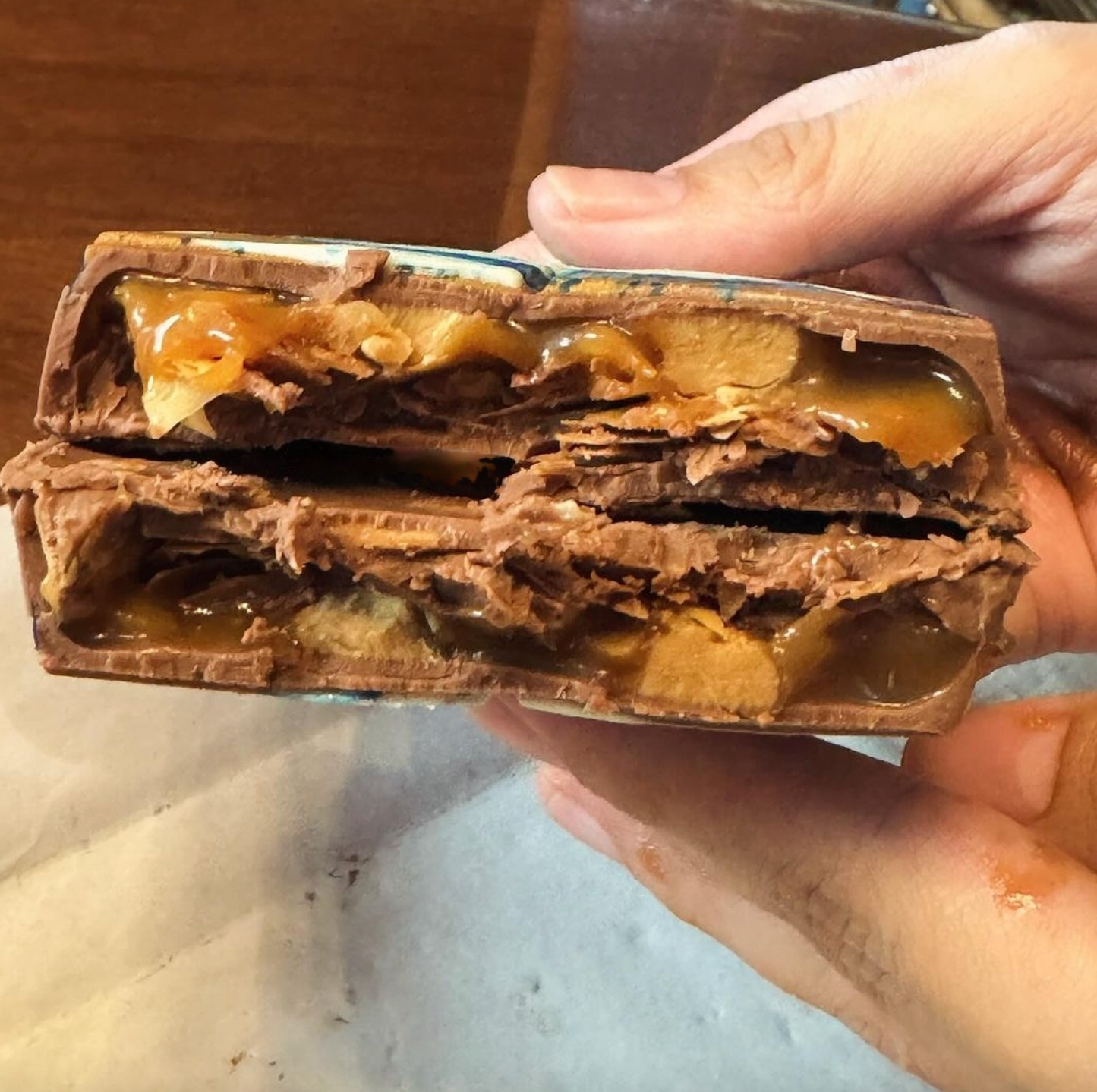 Dubai-Schokoladentafel mit Karamell und Erdnussbuttergeschmack, in zwei Hälften geöffnet
