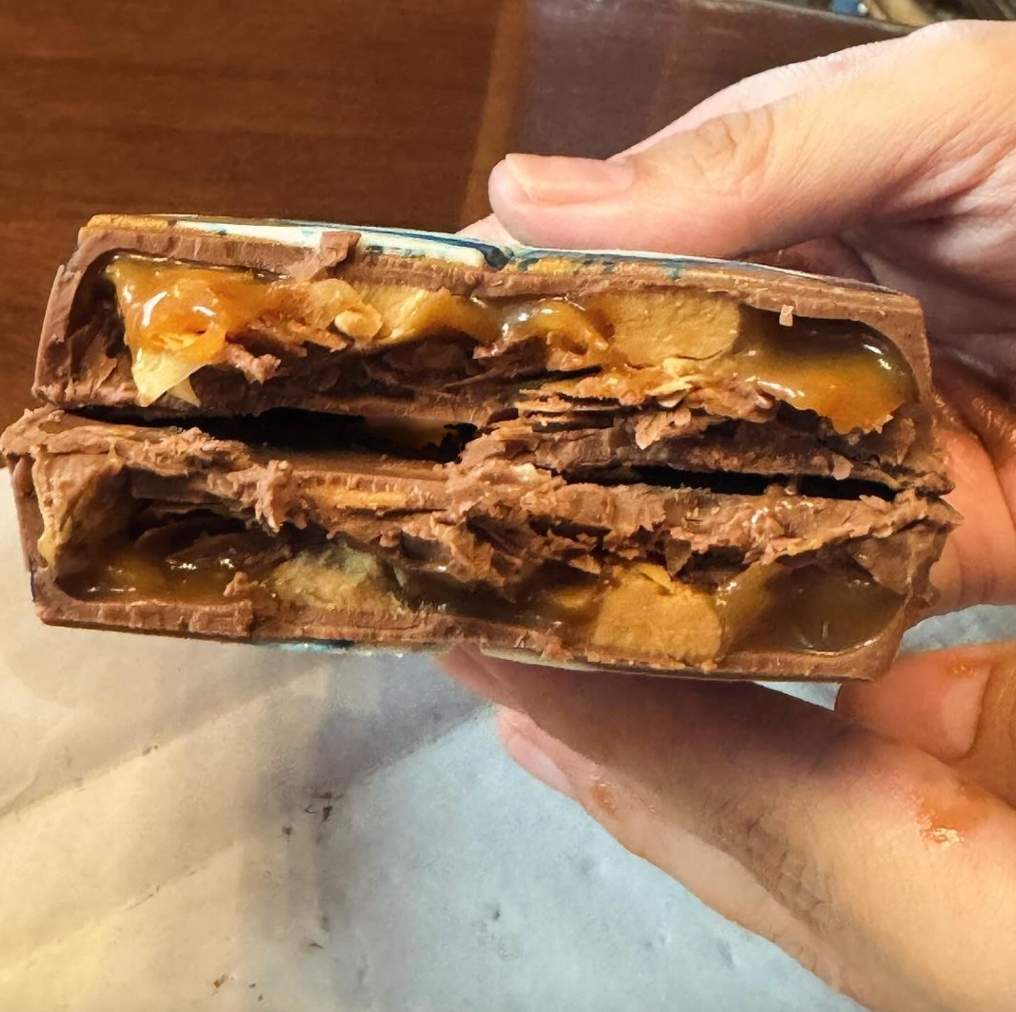 Dubai-Schokoladentafel mit Karamell und Erdnussbuttergeschmack, in zwei Hälften geöffnet